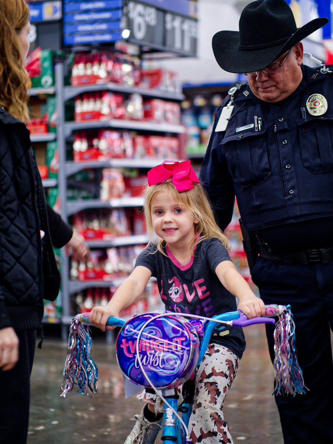 Quitman Police Dept. officer Victor Taylor follows biker Kayleigh Southard to the checkout with her chosen item, already getting in some practice.